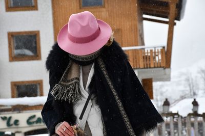 Midsection of person wearing hat standing in snow during winter