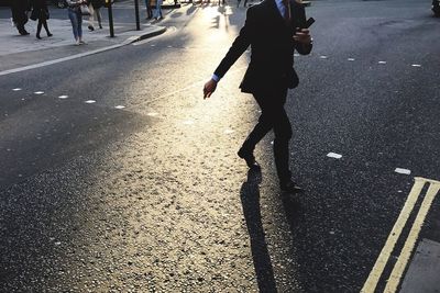 Low section of businessman walking on road