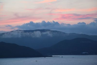 Scenic view of sea and mountains against sky