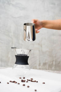 Close-up of hand pouring coffee in cup