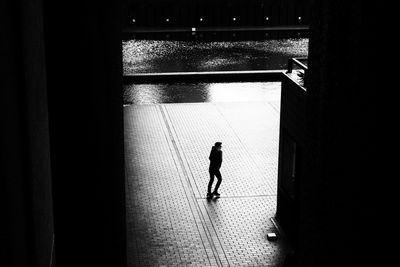 Rear view of silhouette man walking in building