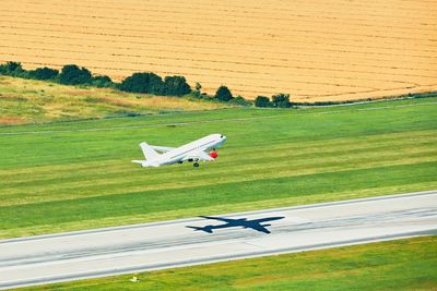 High angle view of airplane taking off at airport runway