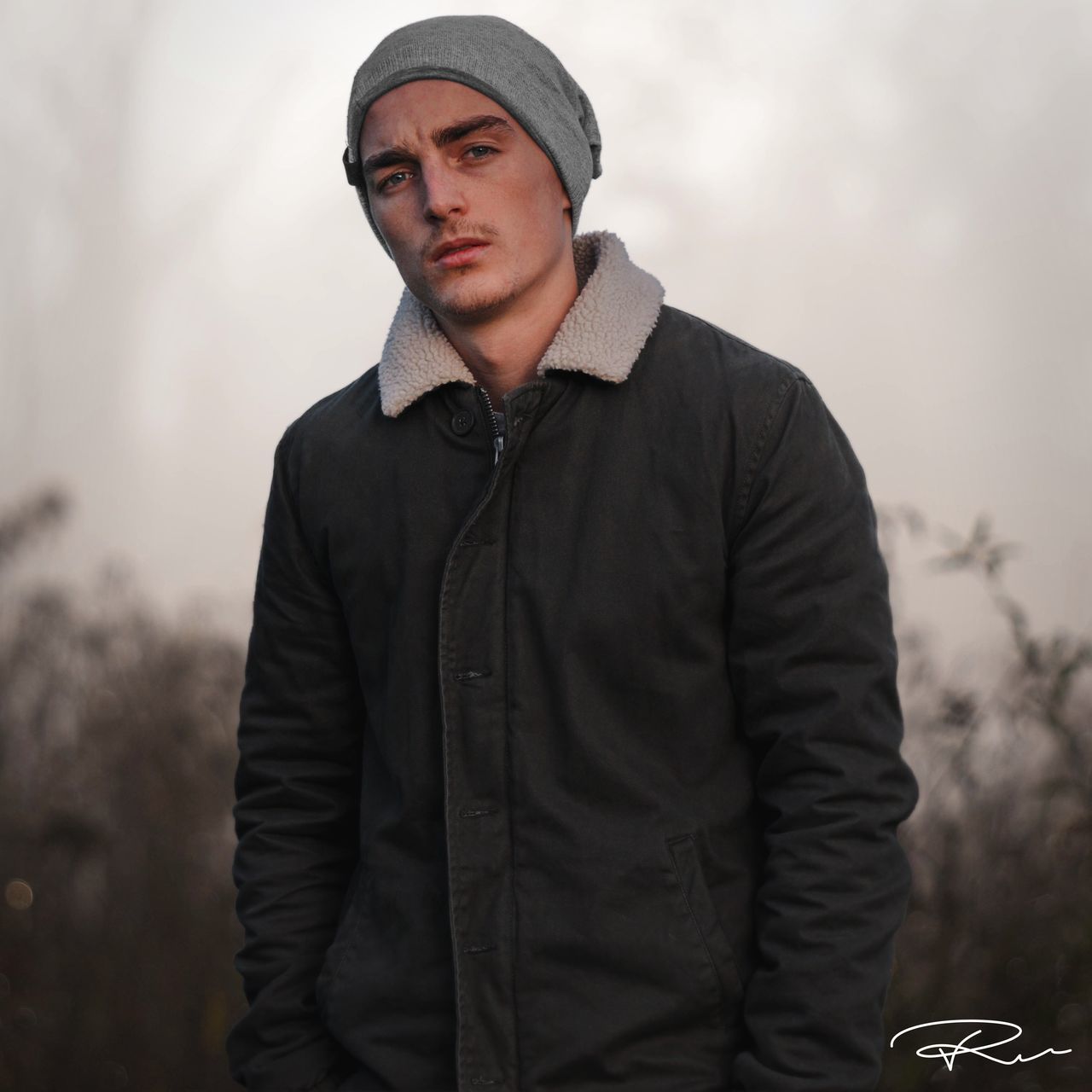 real people, one person, young men, hood - clothing, front view, leisure activity, lifestyles, young adult, focus on foreground, standing, cap, outdoors, hooded shirt, portrait, day, warm clothing, nature, sky