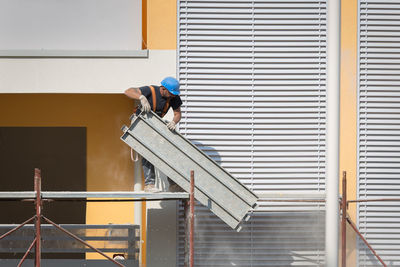 Rear view of man working on building