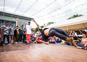 Group of people dancing against sky