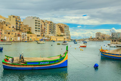 Boats in harbor with buildings in background