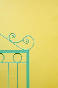 Close-up of gate on yellow wall