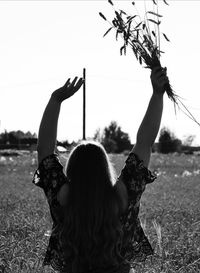 Rear view of woman on field against sky