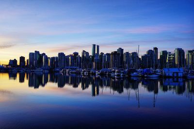 Panoramic view of marina and buildings against sky during sunset