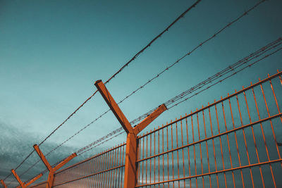 Low angle view of suspension bridge against clear blue sky