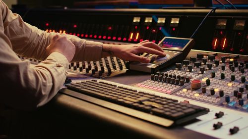 Midsection of man using sound mixer