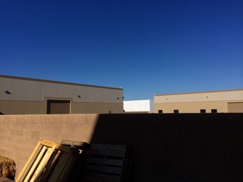 Low angle view of buildings against clear blue sky