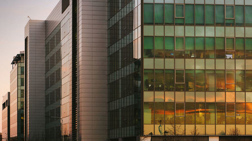 Low angle view of glass building against sky