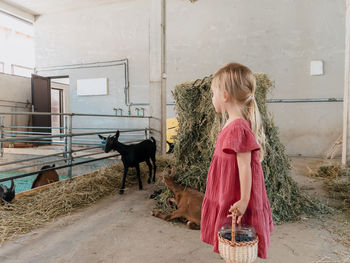 Side view of young woman standing against wall