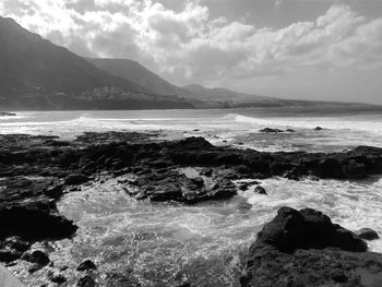 Scenic view of sea and mountains against sky