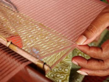 Close-up of human hand holding textile