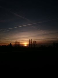 Scenic view of silhouette field against sky at sunset