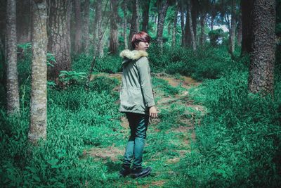 Portrait of young woman standing in forest