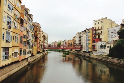 Canal amidst buildings against sky