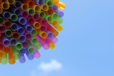 Low angle view of colorful balloons against blue sky