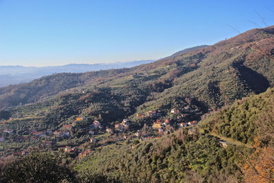 Aerial view of townscape by mountains against clear sky