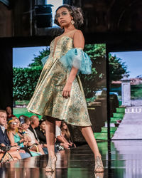 Young woman looking away while standing outdoors