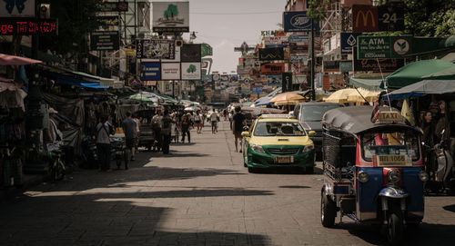 People on street in city against sky