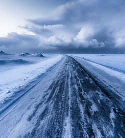Snow covered road against sky