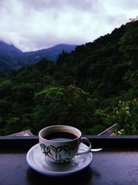 Close-up of coffee cup on table against sky