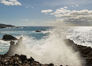 Strong surf on a volcanic beach with stones, spray drops in the back light, canary islands, la palma