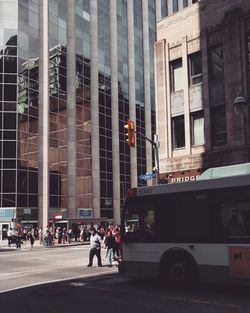 People on city street by modern buildings