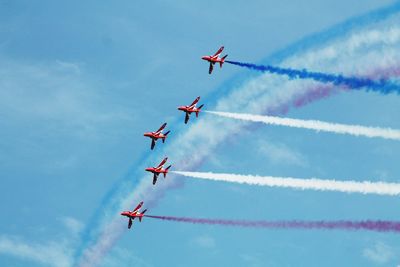 Low angle view of airshow against sky