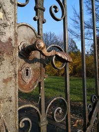 Close-up of rusty metal gate against sky