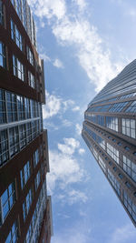 Low angle view of modern building against cloudy sky