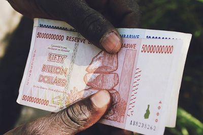 Cropped hands holding paper currencies