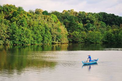 High angle view of man in fishing boat at lake 