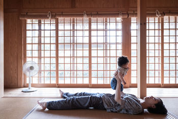 SIDE VIEW OF WOMAN LYING IN WINDOW