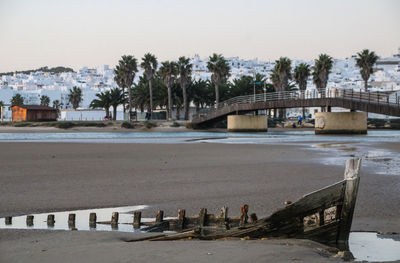 Bridge over river in city against clear sky