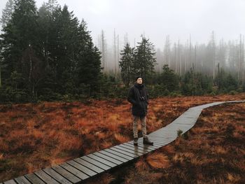 Man standing in forest against sky