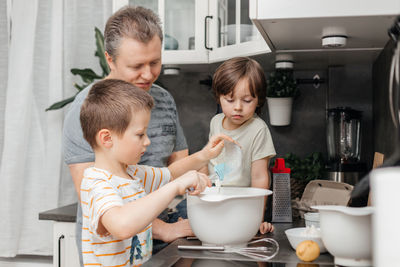 Father with sons in kitchen