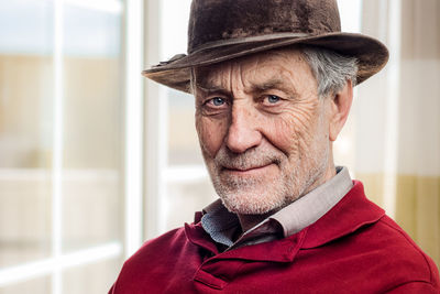 Close-up portrait of senior man wearing hat