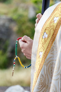 Midsection of person holding prayer bead