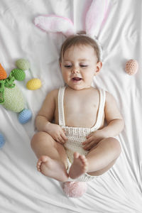 High angle view of baby lying on bed at home