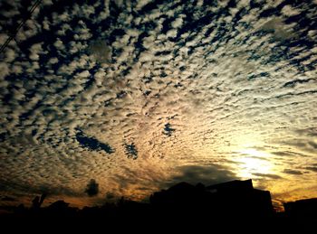 Silhouette of buildings against sky at sunset