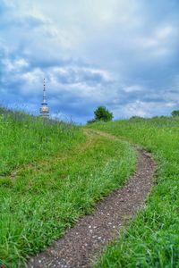 Road amidst field against sky