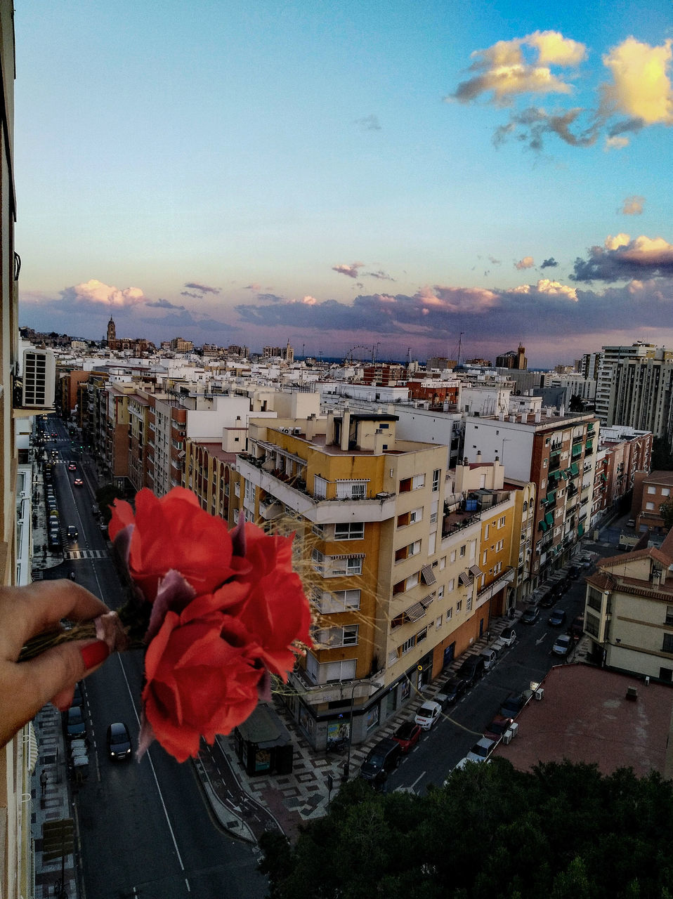 PEOPLE PHOTOGRAPHING BY BUILDINGS AGAINST SKY AT SUNSET