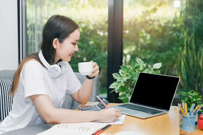 Young woman using laptop at home