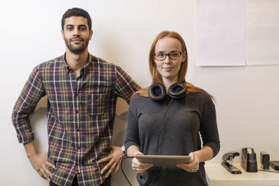 Portrait of confident business colleagues standing by in creative office