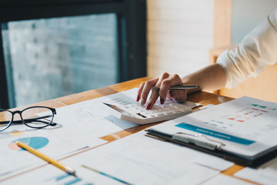 Close-up of business colleagues working on table