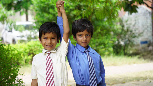 Portrait of boy standing against trees